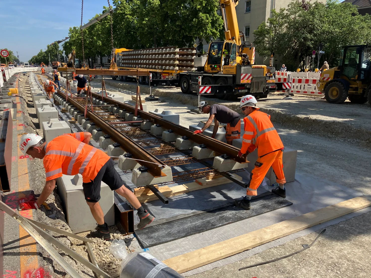 Die Gleise für die Tram-Westtangente in der Fürstenrieder Straße werden mit einem Kran an ihren künftigen Platz gehoben. Die Gleise für die Tram-Westtangente in der Fürstenrieder Straße werden mit einem Kran an ihren künftigen Platz gehoben.
